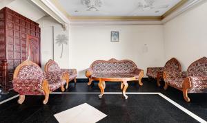 Habitación con 4 sofás, mesa y sillas. en Itsy By Treebo - The Waters Edge Beach Resort, en Kovalam