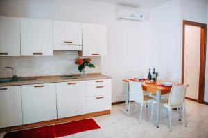 a kitchen with a wooden table and white cabinets at Camping Wien in Peschiera del Garda