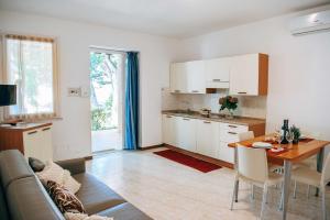 eine Küche und ein Wohnzimmer mit einem Tisch und einem Sofa in der Unterkunft Camping Wien in Peschiera del Garda