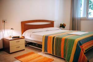 a bedroom with a bed and a nightstand with a bed sidx sidx at Camping Wien in Peschiera del Garda