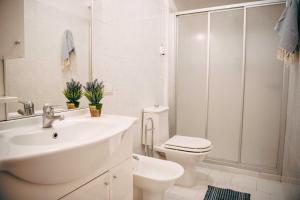 a white bathroom with a sink and a toilet at Camping Wien in Peschiera del Garda