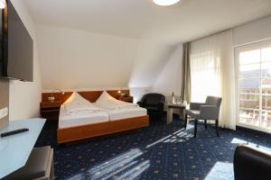 ein Hotelzimmer mit einem Bett und einem Schreibtisch in der Unterkunft Hotel Zur Linde in Neddenaverbergen