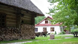 un bâtiment avec une pile de bûches à côté d'une maison dans l'établissement Siedlisko Lubicz Stara Chata Kazimierz Dolny, à Kazimierz Dolny