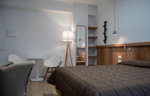een slaapkamer met een bed, een bureau en een stoel bij Hotel Oliva in Aviano