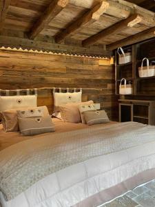 duże łóżko w pokoju z drewnianymi ścianami w obiekcie Calme et sérénité 4 étoiles pour vos séjours VSD ou + w mieście Sixt