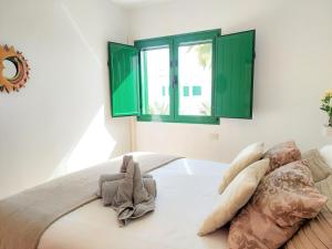 コティージョにあるOcean Balcony by Sea You There Fuerteventuraの緑の窓とベッドが備わるベッドルーム1室