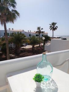 コティージョにあるOcean Balcony by Sea You There Fuerteventuraの植物のテーブルに座るガラス瓶