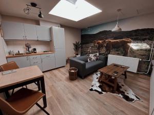 a kitchen and a living room with a couch and a table at Loods 123 bed & kitchen in Landgraaf