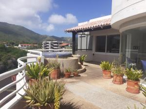 a patio with potted plants on a house at PENTHOUSE EN PLAYA EL AGUA in Los Cerritos