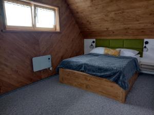 1 dormitorio con 1 cama en una habitación de madera en Na Południe, en Białka Tatrzanska