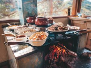 a buffet with food on a table next to a fire at Pousada Espelho Dagua in Gonçalves