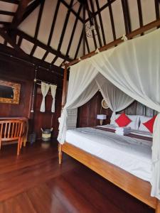 a bedroom with a large bed with a canopy at Mirabelle Joglo Village in Karimunjawa +45 photos