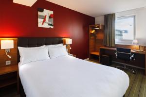 a hotel room with a large bed and a desk at Holiday Inn Clermont Ferrand Centre, an IHG Hotel in Clermont-Ferrand
