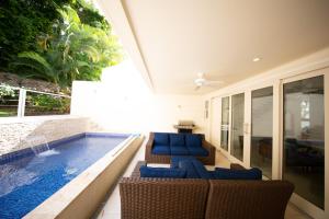 a patio with a swimming pool and blue chairs and a swimming pool at Luxury 3-Bed Villa St James near Beach & Gym in Saint James