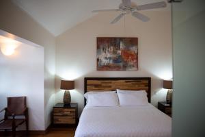 Luxury 3-Bed Villa St James near Beach & Gym في سانت جيمس: غرفة نوم بسرير ومروحة سقف