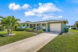 a house with a garage and a palm tree at Sunny Side Up in Cape Coral