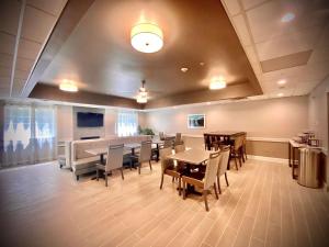 une salle à manger avec des tables et des chaises en bois et un plafond dans l'établissement Best Western Brockport Inn & Suites, à Brockport