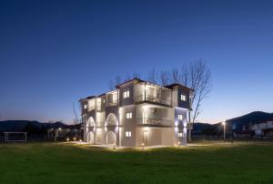 un grande edificio in un campo di notte di Grand Garden Slow Living Experience a Sikia