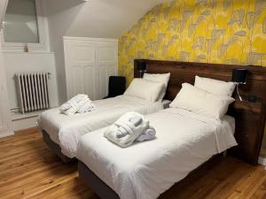 two beds with towels on them in a bedroom at Ô SAINT MICHEL in Saint-Michel-de-Maurienne