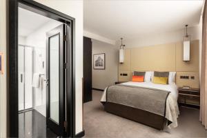 a bedroom with a bed and a mirror at Montcalm Royal London House, London City in London