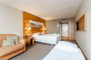 une chambre d'hôtel avec deux lits et un canapé dans l'établissement Private Suite with stunning sea view, à Zandvoort