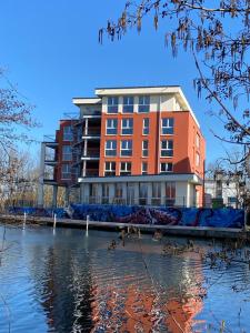 un gran edificio junto a una masa de agua en Havel-Spitze Ferienwohnungen, en Brandenburg an der Havel