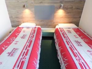 dos camas sentadas una al lado de la otra en una habitación en Fasthotel Poitiers Futuroscope, en Jaunay-Clan