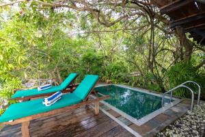 una terraza con sillas y una piscina en Nature Cabanas & Floating Restaurant en Galle