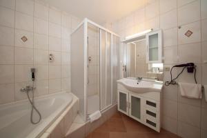 a white bathroom with a tub and a sink at Hotel Maximilian in Zeitz +30 photos