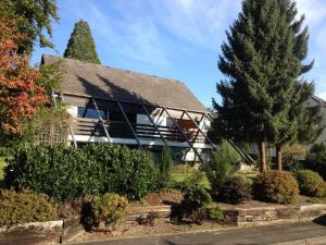 a house with a conservatory with trees and bushes at Ferienwohnung Fröschenpuhl NEU in Traben-Trarbach