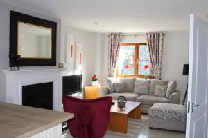 ein Wohnzimmer mit einem Sofa und einem Kamin in der Unterkunft Cosy Holidayhomes Kenmare in Kenmare