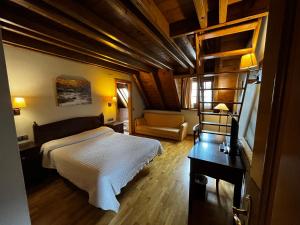 a bedroom with a bed and a desk and a chair at Hotel Ço De Pierra in Betrén