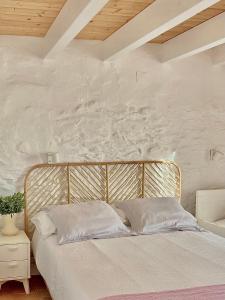 1 cama en un dormitorio con una pared blanca en Casa no Montinho, en Ourique
