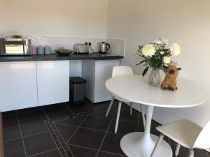 una cocina con una mesa blanca y un jarrón de flores en Strath View on the NC 500 en Culbokie