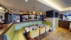 a dining room with a table and yellow chairs at Holiday Inn Milton Keynes Central by IHG in Milton Keynes +154 photos