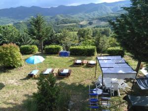 a group of chairs and umbrellas in a yard with mountains at Ca' Lilli in Cantiano