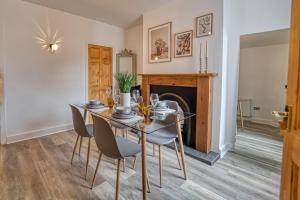 a dining room with a table and chairs and a fireplace at Guest Homes - The Buck House in Worcester