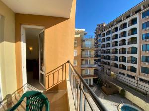 Un balcón de un edificio de apartamentos con una silla verde en BLUE MARINE C16 Apartment Sunny Beach en Sunny Beach