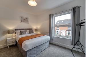 a bedroom with a bed and a large window at Guest Homes - The Buck House in Worcester