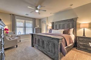 a bedroom with a large wooden bed and a chair at Bright Goodyear Retreat with Home Gym, Near Golfing in Goodyear