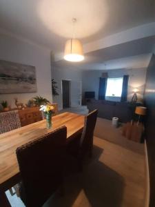 a living room with a wooden table with chairs at Stunning Riverside Town House with views Ayrshire in Girvan