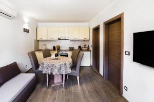 una sala da pranzo con tavolo e sedie e una cucina di Premium holiday home Maslina in Podstrana a Podstrana