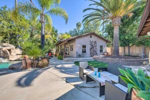 a backyard with palm trees and a house at Bright Poway Studio with Shared Outdoor Oasis! in Poway