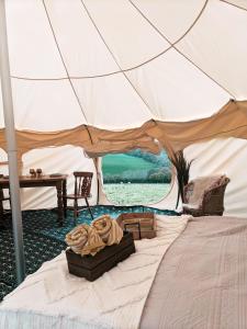 ein Zelt mit einem Haufen Decken auf einem Bett in der Unterkunft Immaculate Lotus Belle Tent Retreat North Devon in Bideford