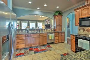a large kitchen with wooden cabinets and stainless steel appliances at Grand Hot Springs Home Less Than 5 Mi to Lake Desoto! in Hot Springs Village