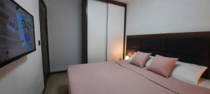 a bedroom with a large white bed with pink pillows at Apartman M&S - Zoned 2 in Kopaonik +28 photos