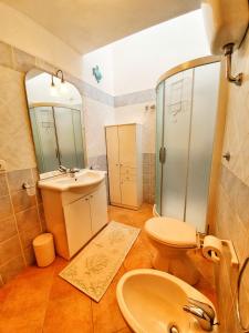 uma casa de banho com um lavatório, um WC e um espelho. em Casa Il Nicchio em Àrbatax