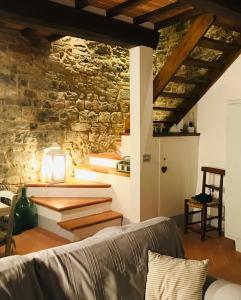 a living room with a couch and a stone wall at Guelfi6 Poppi in Poppi