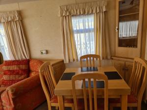 uma sala de estar com uma mesa e cadeiras e um sofá em 6 Berth central heated The Grange (Balmoral II) em Ingoldmells