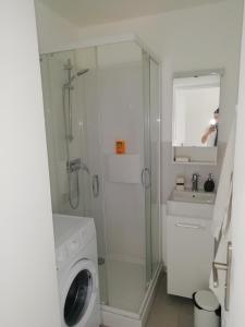 ein Badezimmer mit einer Waschmaschine und einem Waschbecken in der Unterkunft Le Miroir de la mer in Saint-Aygulf